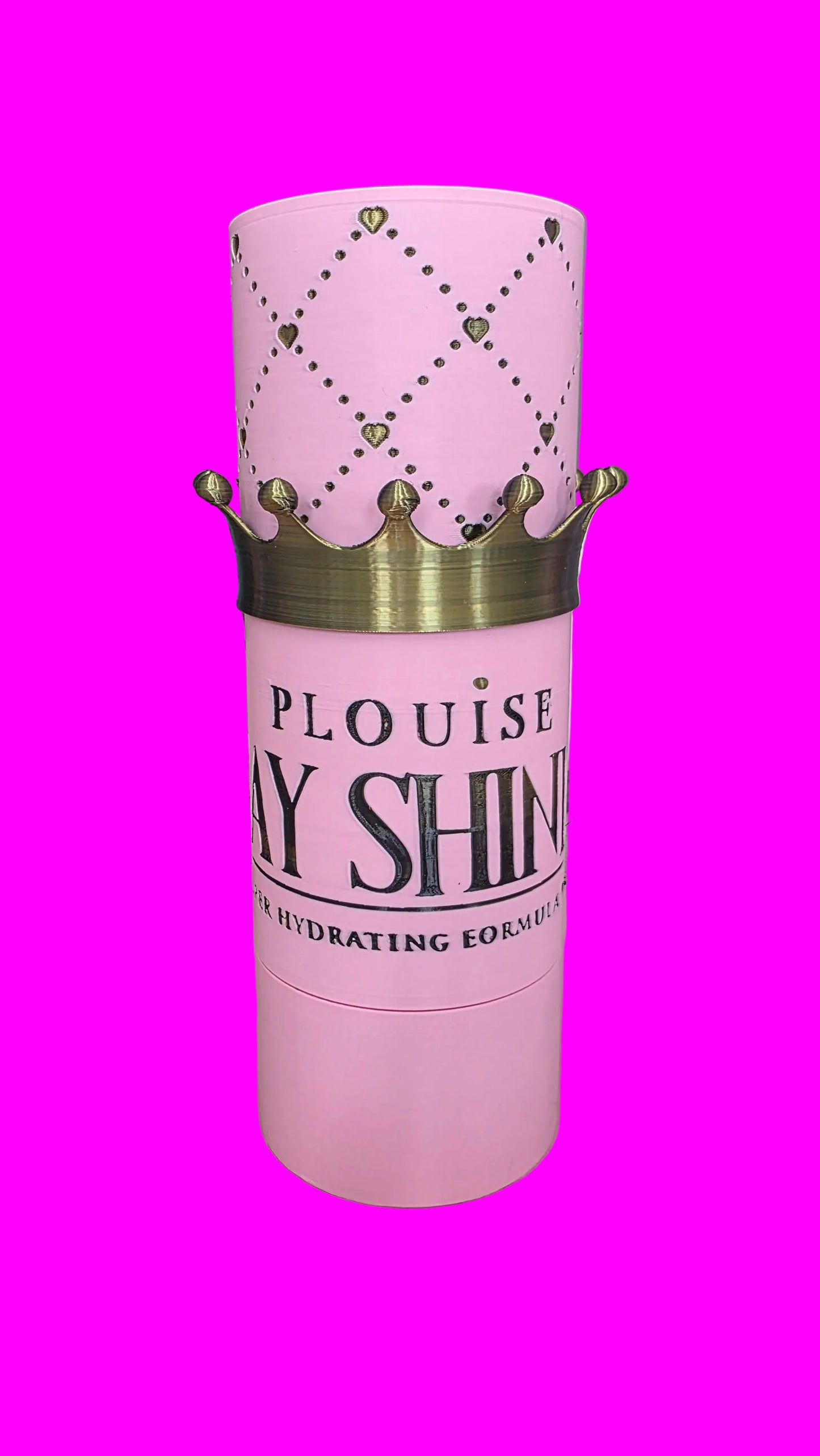 Pink cylindrical cosmetic container with a gold crown graphic and the text 'PLOUISE DAY SHINE' on the front, set on a pink surface