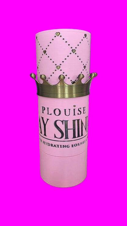 Pink cylindrical cosmetic container with a gold crown graphic and the text 'PLOUISE DAY SHINE' on the front, set on a pink surface
