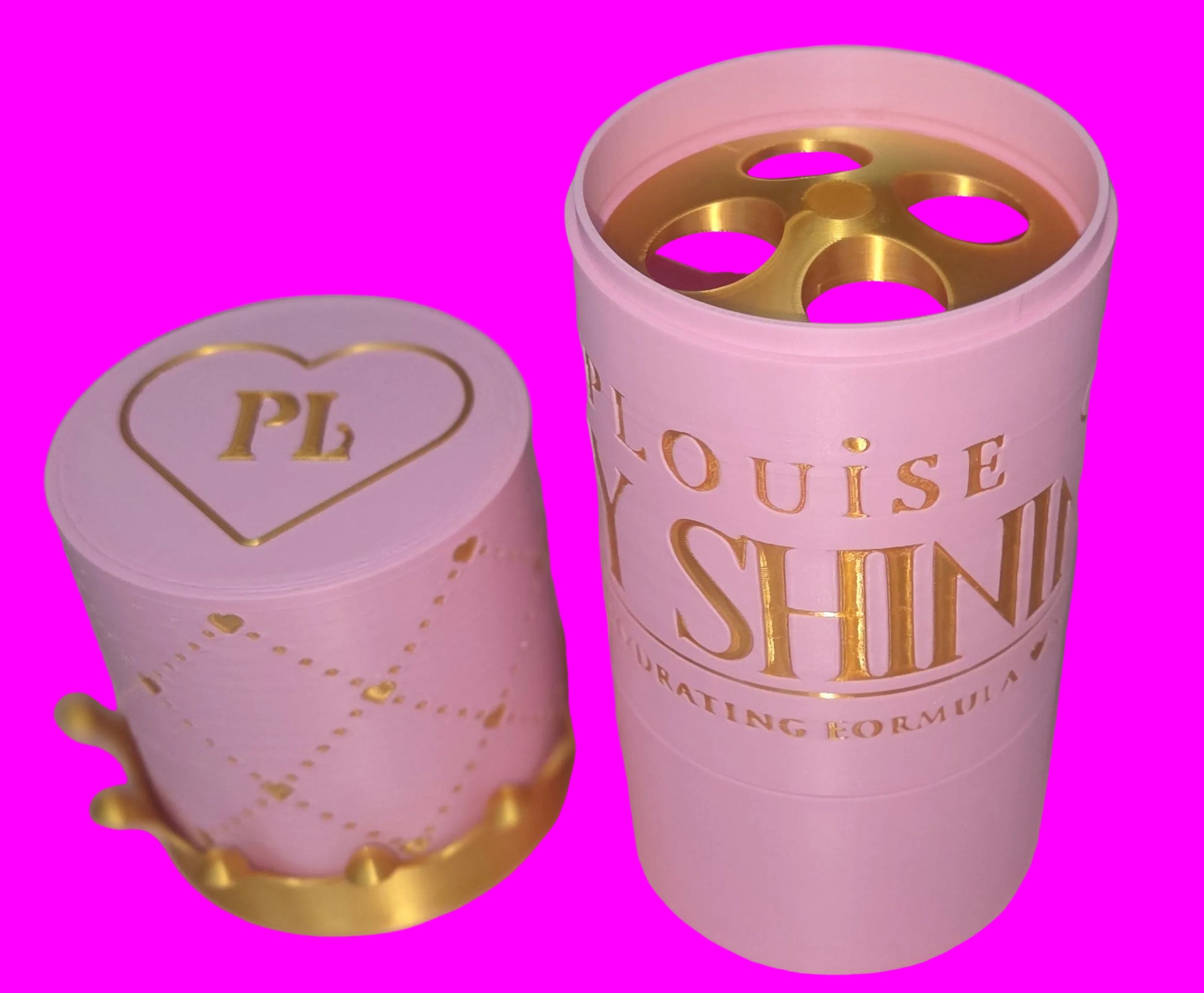 A pink cylindrical cosmetic container with its matching lid beside it, featuring gold lettering that reads 'Louise Shine Gratifying Formula' and a gold heart emblem on the lid. The container is open, showing pink and gold product pieces inside.